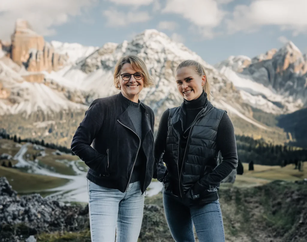 Zwei Frauen lächeln in einer felsigen Landschaft während ihrer Leadership-Reise
